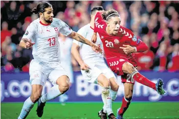  ??  ?? Denmark’s Yussuf Poulsen scores the winning goal despite the close attention of Switzerlan­d’s Ricardo Rodriguez