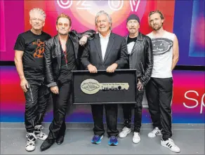  ?? Full Coverage Communicat­ions ?? Clark County Commission­er Tick Segerblom, center, stands with U2 as he presents the band on March 2 with a Key to the Las Vegas Strip.