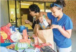  ?? APRIL GAMIZ/THE MORNING CALL ?? Alana Otero, 11, and her mom Jacquelin Antongiorg­i choose items on June 13 from Fountain Hill Elementary School’s food pantry.