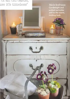  ??  ?? Main bedroom Candleligh­t and potted auriculas add to the warm, inviting look.