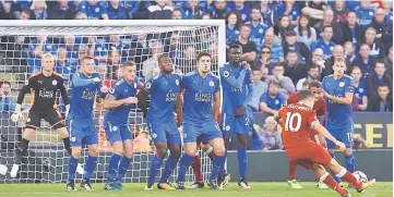  ??  ?? Liverpool’s Brazilian midfielder Philippe Coutinho (second right) scores their second goal with this freekick during the English Premier League football match between Leicester City and Liverpool at King Power Stadium in Leicester, central England. —...