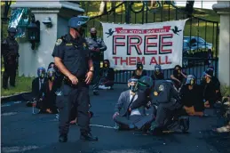  ?? DANIEL KIM. — THE SACRAMENTO BEE VIA AP ?? A California Highway Patrol officer inspects a chained protester outside of California Gov. Gavin Newsom’s mansion in Fair Oaks on July 27.