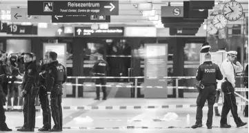  ??  ?? Police cordon off the scene at the main train station in Duesseldor­f, western Germany after at least five people where injured by a man with an axe. — AFP photo