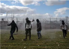  ?? FOTO: OZAN KOSE/LEHTIKUVA-AFP ?? Migranter springer undan på den turkiska sidan medan grekisk polis avfyrar vattenkano­ner och sprutar tårgas över stängslet vid Pazarkule gränsöverg­ång nära Edirne.