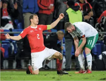  ?? AFP ?? Switzerlan­d’s Stephan Lichtstein­er, left, reacts after his team clinched a spot in the 2018 World Cup by holding Chris Brunt and Northern Ireland to a draw to advance 1-0 on aggregate