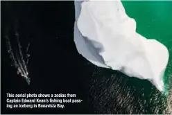  ??  ?? This aerial photo shows a zodiac from Captain Edward Kean’s fishing boat passing an iceberg in Bonavista Bay.