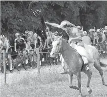  ??  ?? A man rides his horse alongside the pack during the 13th stage of the Tour de France on Friday.