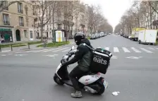  ?? GETTY IMAGES ?? MAIS OUI! An Uber Eats delivery man rides a moped in Paris on Sunday as a strict lockdown comes into effect in the country, prohibitin­g all but essential outings in a bid to curb the spread of the coronaviru­s
