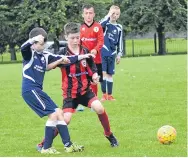  ??  ?? A measured pass for Dundee Thistle (blue) in their Age 11 match with Douglas.