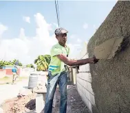  ?? FILE ?? In this February 8, 2018 photograph, Michael Logan roughcasts a wall erected in Denham Town under the Zinc Fence Removal Project, which was part of social interventi­on under ZOSO.