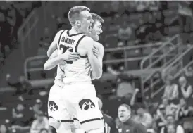  ?? GRACE SMITH/GETTY IMAGES ?? Iowa forward Payton Sandfort hugs younger brother Pryce to celebrate the Hawkeyes’ 90-81 win against the Nittany Lions.