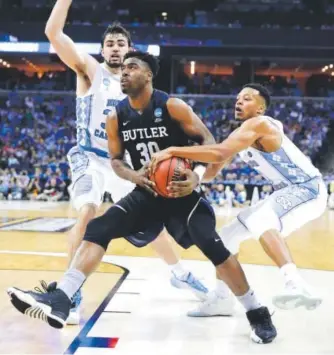  ??  ?? Butler’s Kelan Martin drives as North Carolina’s Luke Maye, left, and Nate Britt defend Friday night. The Tar Heels won 92-80. Andy Lyons, Getty Images