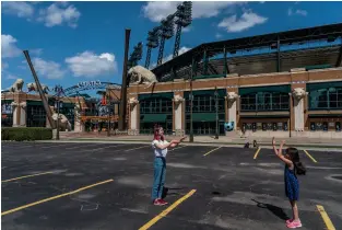  ??  ?? DETROIT The Only Game in Town Two girls play catch in the empty parking lot outside Comerica Park, home of the Detroit Tigers, April 8. Photograph by Ryan Garza