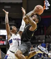  ?? JOHN WOIKE / TNS ?? UCF’s Ceasar DeJesus shoots over UConn’s Christian Vital in the Huskies’ 62-53 victory Wednesday in Storrs, Conn. DeJesus scored 13 for the Knights.