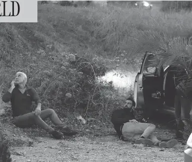  ?? JACK GUEZ / AFP / GETTY IMAGES ?? Israelis take cover as rockets are fired from the Gaza Strip into the southern Israeli town of Sderot on Monday, after an attempted incursion into Gaza by Israeli commandos on Sunday night went wrong.