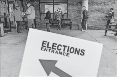  ?? DAVID GOLDMAN AP PHOTO ?? Voters line up Thursday as the doors open to the Election Center for absentee early voting for the general election in Sterling Heights, Mich.