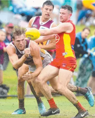  ?? TIMING: Lions player Tom Bell gets a handball away during yesterday’s trial game. ??