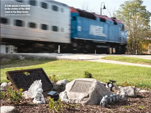  ?? ASHLEE REZIN GARCIA/ SUN- TIMES ?? A train passes a memorial to the victims of the 1995 crash in Fox River Grove.