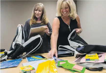  ?? ERROL McGIHON ?? Edith Moloughney, left, program co-ordinator with the Caldwell Family Centre, and Cindy Smith, executive director with The Caring and Sharing Exchange, pack backpacks with school supplies on Friday. Moloughney says the influx of Syrian refugees means...