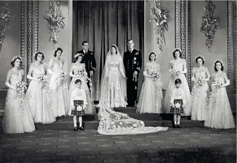  ??  ?? Dans la salle du trône de Buckingham, le couple royal et les demoiselle­s d'honneur, le jour du mariage, le 20 novembre 1947.