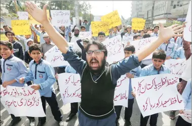  ?? Reuters ?? Student supporters of the Jamaat-ud-dawa protest in Karachi against the detention of Saeed (below).