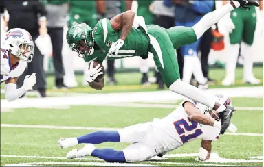  ?? Elsa / Getty Images ?? The Jets’ Denzel Mims is upended by the Bills’ Jordan Poyer (21) on Sunday in East Rutherford, N. J.