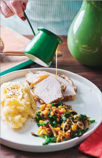  ?? ASSOCIATED PRESS ?? GRAVY IS POURED on a plate of turkey, mashed potatoes and gravy and a side of sauteed broccoli rabe, corn and onions with crispy bacon, on a table in New York. If you remember that the turkey breast will take less time to cook than the legs, and that you can get a head start on your gravy, Thanksgivi­ng will be a whole lot less stressful.