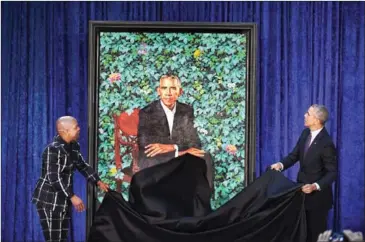  ??  ?? Artist Kehinde Wiley (left) and former President Barack Obama unveil Obama’s official portrait on Monday at the National Portrait Gallery in Washington, DC.