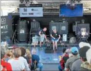  ??  ?? G Bryan, left, and Heather Spiewak work to shape glass at the Corning Museum of Glass’s GlassBarge on Staurday, July 7, 2018.