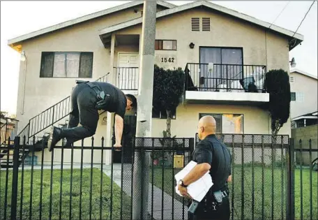  ?? Rick Loomis Los Angeles Times ?? LAPD OFFICERS in 2007 serve a notice of a gang injunction, a court order that restricts whom a person may associate with in public.