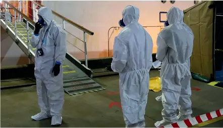  ?? AP ?? Investigat­ors in protective gear prepare to board the Ruby Princess cruise ship in Wollongong on Wednesday