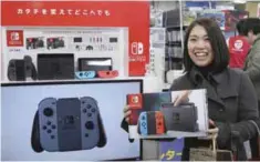  ?? —AP ?? TOKYO: Nao Imoto, 31-years-old, shows off Nintendo’s newest computer game console Switch at a retail store Bic Camera in central Tokyo, yesterday.