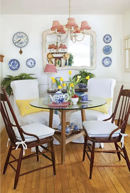  ??  ?? BLUE-PLATE SPECIAL. Blueand-white plates and tea sets dot the dining room. The smallest room
in the house, it has low ceilings,
so Erin placed mirrors on each
end to make it look bigger and brought in an old antique table and had a glass top made...