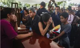  ??  ?? Family members and fellow officers mourn pay tribute to the officers killed in an ambush on Monday. At least 30 gunmen opened fire on the convoy of state police officers. Photograph: Enrique Castro/AFP via Getty Images