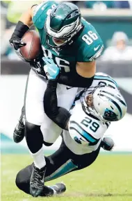  ?? AP ?? Philadelph­ia Eagles tight end Zach Ertz (top) is tackled by Carolina Panthers free safety Mike Adams during the first half of an NFL game in Philadelph­ia yesterday.
