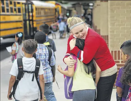  ??  ?? First-year teacher Audrey Smith hugs Carolyn Do goodbye while walking her students to the buses on the last day of school at Baldwin Elementary School in Norcross. Smith said she’s learned from various mistakes and endured some financial hardships. But...