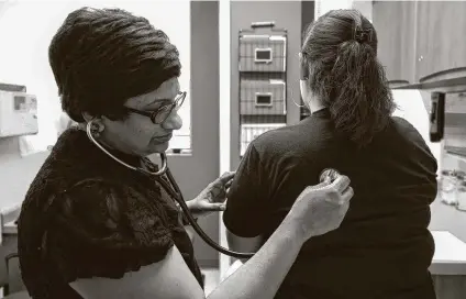  ?? Godofredo A. Vásquez / Staff file photo ?? Dr. Vishalaksh­mi Batchu examines a patient at her primary care clinic in Pearland. She and her husband, Chandrakan­th Vemula, moved to Pearland in 2011 out of the Houston metro area to pursue their dream of owning their own business.