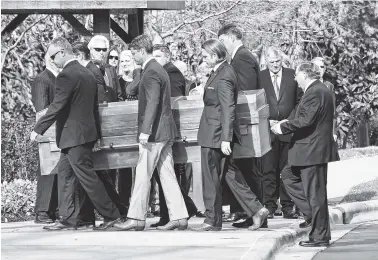  ?? AP PHOTO/KATHY KMONICEK, POOL ?? Pallbearer­s carry the casket with the body of Billy Graham past family members as it arrives Saturday at the Billy Graham Library in Charlotte, N.C.