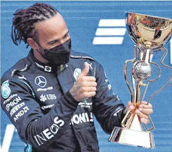  ?? FOTO: ALEXANDER NEMENOV/AFP ?? Pokal Nummer 100 ist offenbar einer, an dem Sotschi-Sieger und Rekordwelt­meister Lewis Hamilton besonders viel Gefallen findet.