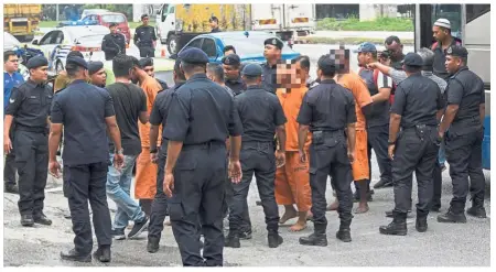  ?? — Bernama ?? Tell us what happened: Police officers bringing in several suspects being held in connection with the fracas at the temple to the area of incident to facilitate the investigat­ions.