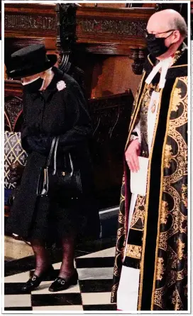  ??  ?? SOMBRE MOMENT: The Queen sits alone in the stalls at St George’s Chapel, top, and above, being led inside by the Dean of Windsor, David Conner