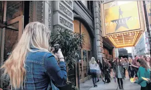 ?? AP PHOTO ?? In this photo taken in October, Alex Richards takes a photo of Meera Ganesh outside the CIBC Theatre after watching “Hamilton: An American Musical” in Chicago. They were among the approximat­ely 2,000 first-year students at Northweste­rn University who...