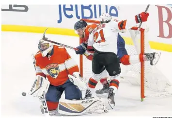  ?? JOE SKIPPER/AP ?? Florida Panthers defenseman Aaron Ekblad (5) and New Jersey Devils right wing Kyle Palmieri (21) collide with the goal behind Panthers goaltender Roberto Luongo (1) during the first period on Thursday.