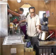  ??  ?? Tan makes coffee for his customers at his shop.