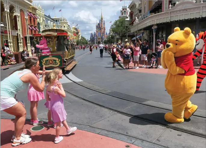  ?? ?? Young guests enjoy seeing Winnie The Pooh, and Tigger too, at the Magic Kingdom at Walt Disney World, in Lake Buena Vista, Florida.(Joe Burbank/Orlando Sentinel/TNS)