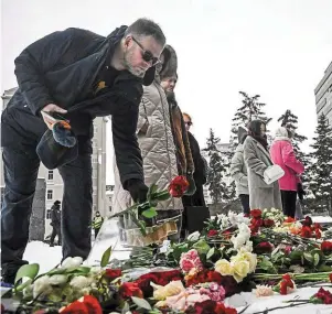  ?? | PHOTO : ALEXANDER NEMENOV, AFP ?? Des passants déposant des fleurs devant le monument aux victimes de la répression soviétique, hier à Moscou.