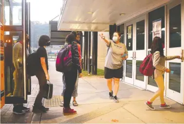  ?? STAFF PHOTO BY ROBIN RUDD ?? Red Bank Middle School girls’ physical education teacher Deanna Wilson directs arriving student to the correct hallways for their grades.