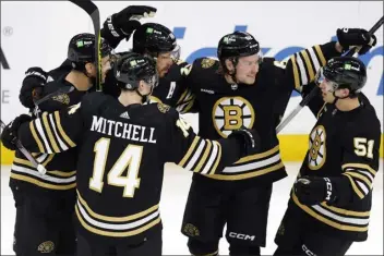  ?? MICHAEL DWYER — THE ASSOCIATED PRESS ?? Boston Bruins’ David Pastrnak (88) celebrates his goal with teammates Ian Mitchell (14), Kevin Shattenkir­k, left, Oskar Steen (62) and Matthew Poitras (51) during the first period of an NHL hockey game against the Arizona Coyotes, Saturday, Dec. 92023, in Boston.