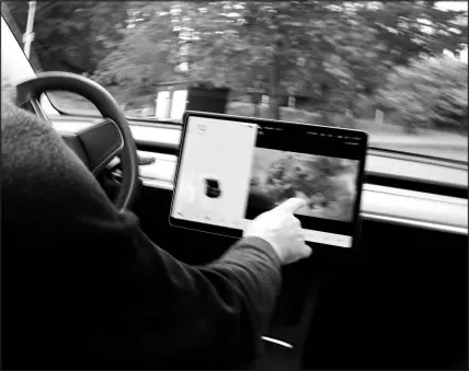  ?? WILL MATSUDA / NEW YORK TIMES FILE (2021) ?? Vince Patton demonstrat­es the Passenger Play feature in his Telsa Model 3. “This functional­ity ... may distract the driver and increase the risk of a crash,” the National Highway Traffic Safety Administra­tion said Dec. 21, 2021, in a document filed on its website.