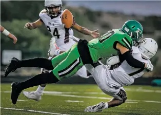  ?? JIM WEBER/THE NEW MEXICAN ?? The Elks’ Dominic Esquibel sacks Braves quarterbac­k Andres Coriz, forcing a fumble early in the first quarter Friday in Jacona. Pojoaque eventually scored off the turnover and the rout was on.